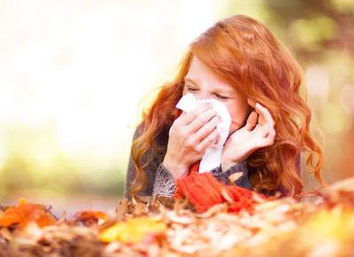 Frau mit Taschentuch an der Nase
